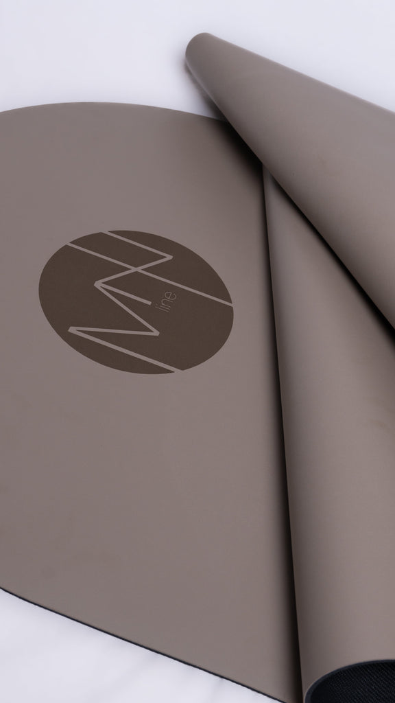 gray yoga mat with a logo on a white background